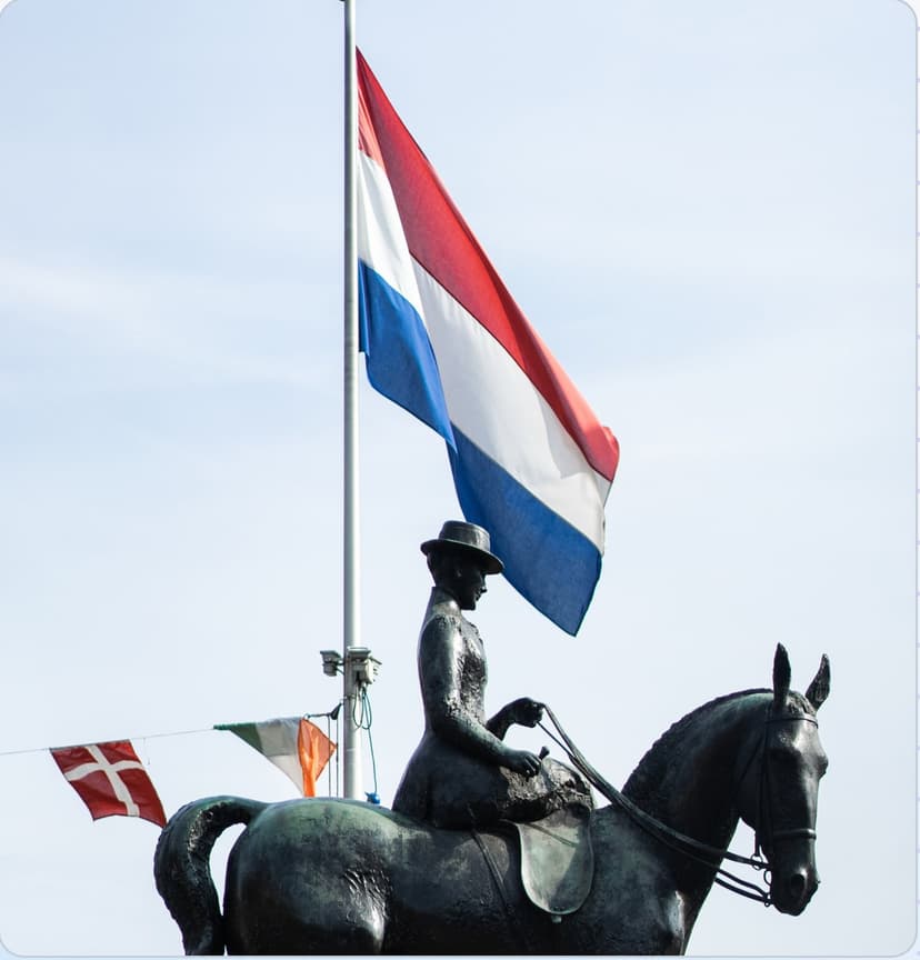 De Nederlandse vlag wappert boven het standbeeld van Wilhelmina in Utrecht